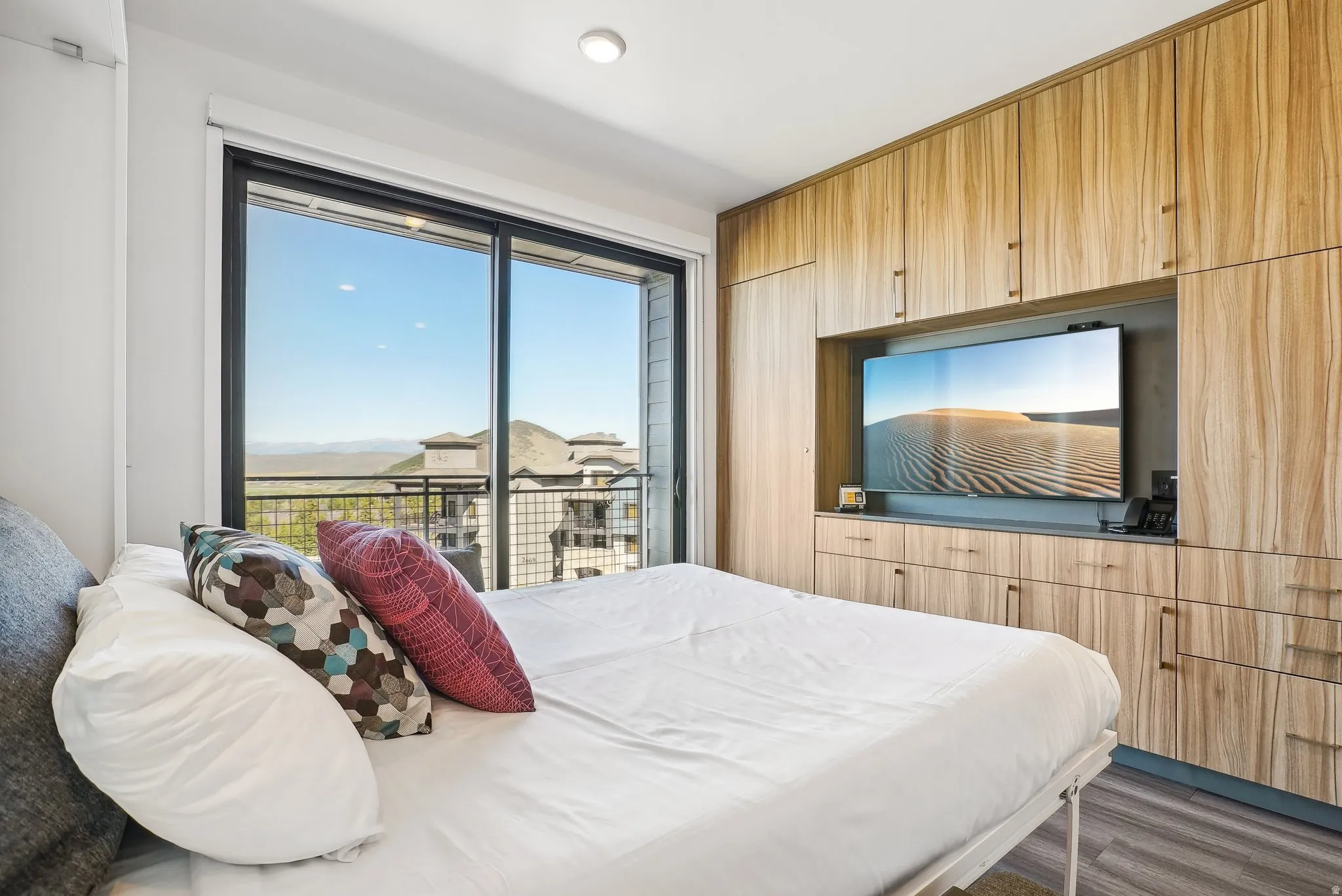 Floor-to-ceiling sliding glass doors open to a private balcony