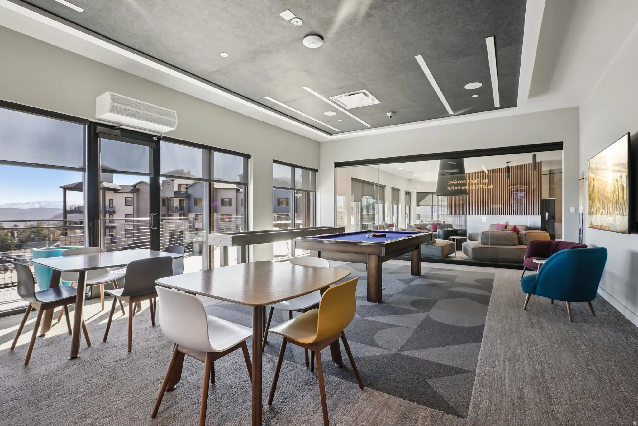 Open common area featuring expansive windows with mountain scenery, a pool table, and multiple seating arrangements