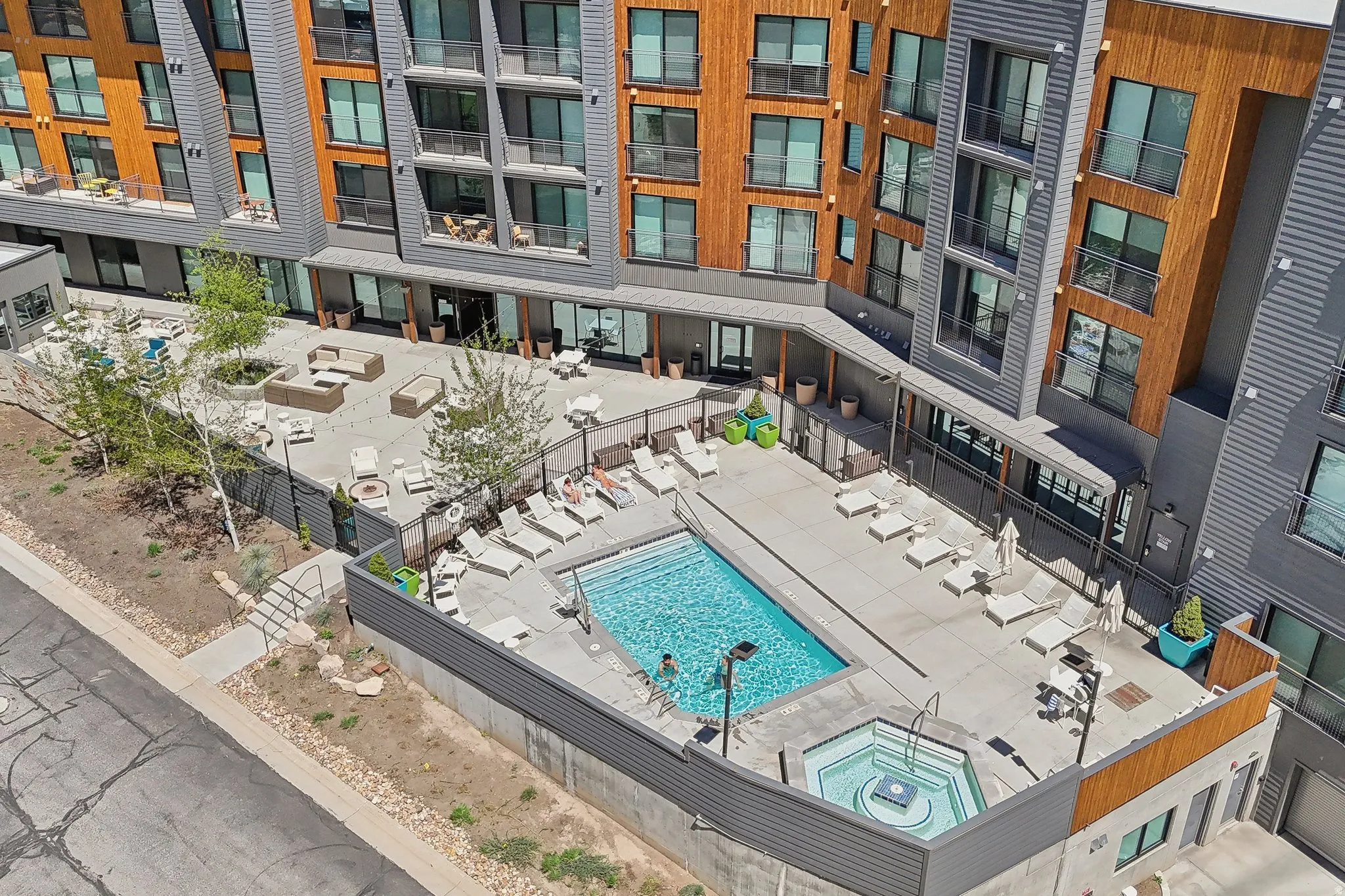 Outdoor amenity area featuring a swimming pool, integrated hot tub, and surrounding lounge seating