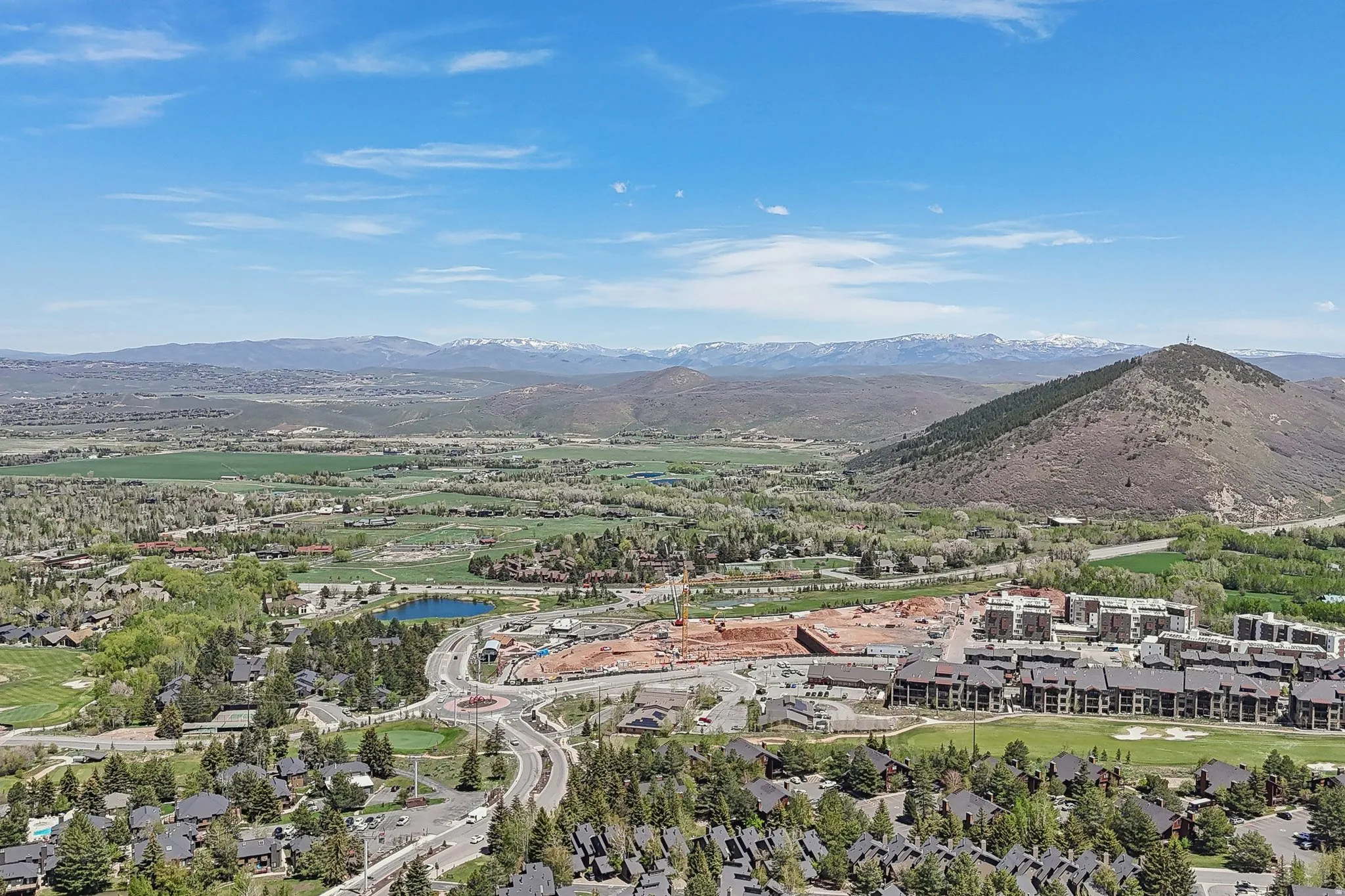 Expansive aerial showcasing a mountainous landscape with snow-capped peaks in the distance