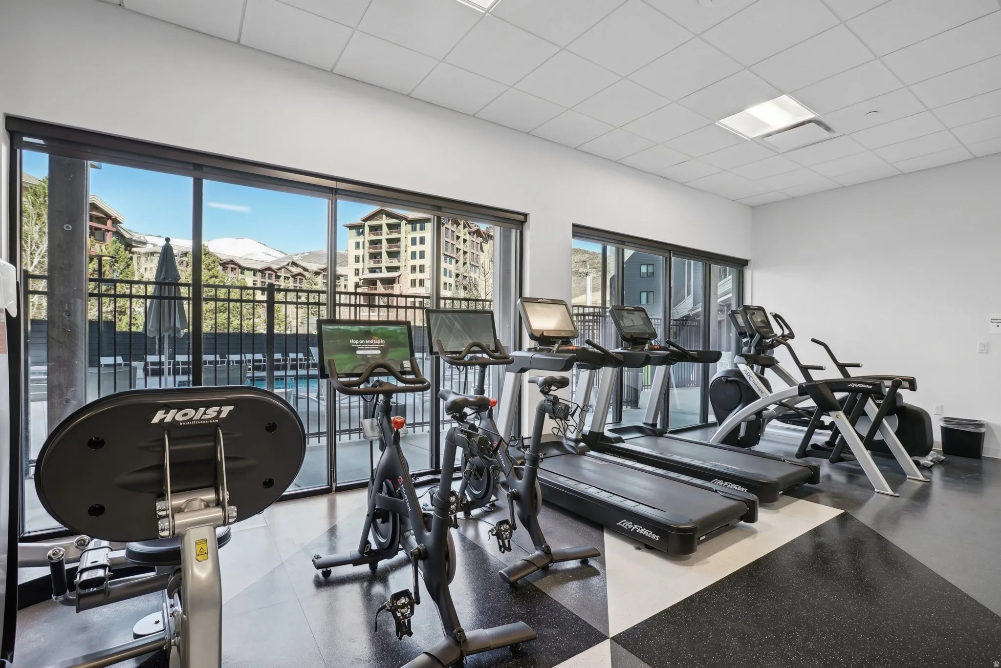 Fitness center with floor-to-ceiling windows, offering ample natural light and exterior views