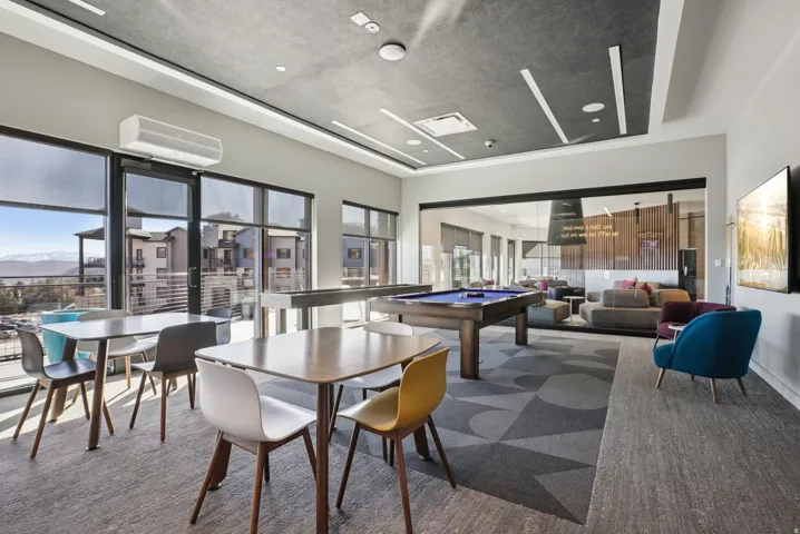 Open common area featuring expansive windows with mountain scenery, a pool table, and multiple seating arrangements