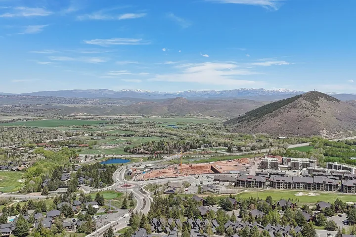 Expansive aerial showcasing a mountainous landscape with snow-capped peaks in the distance