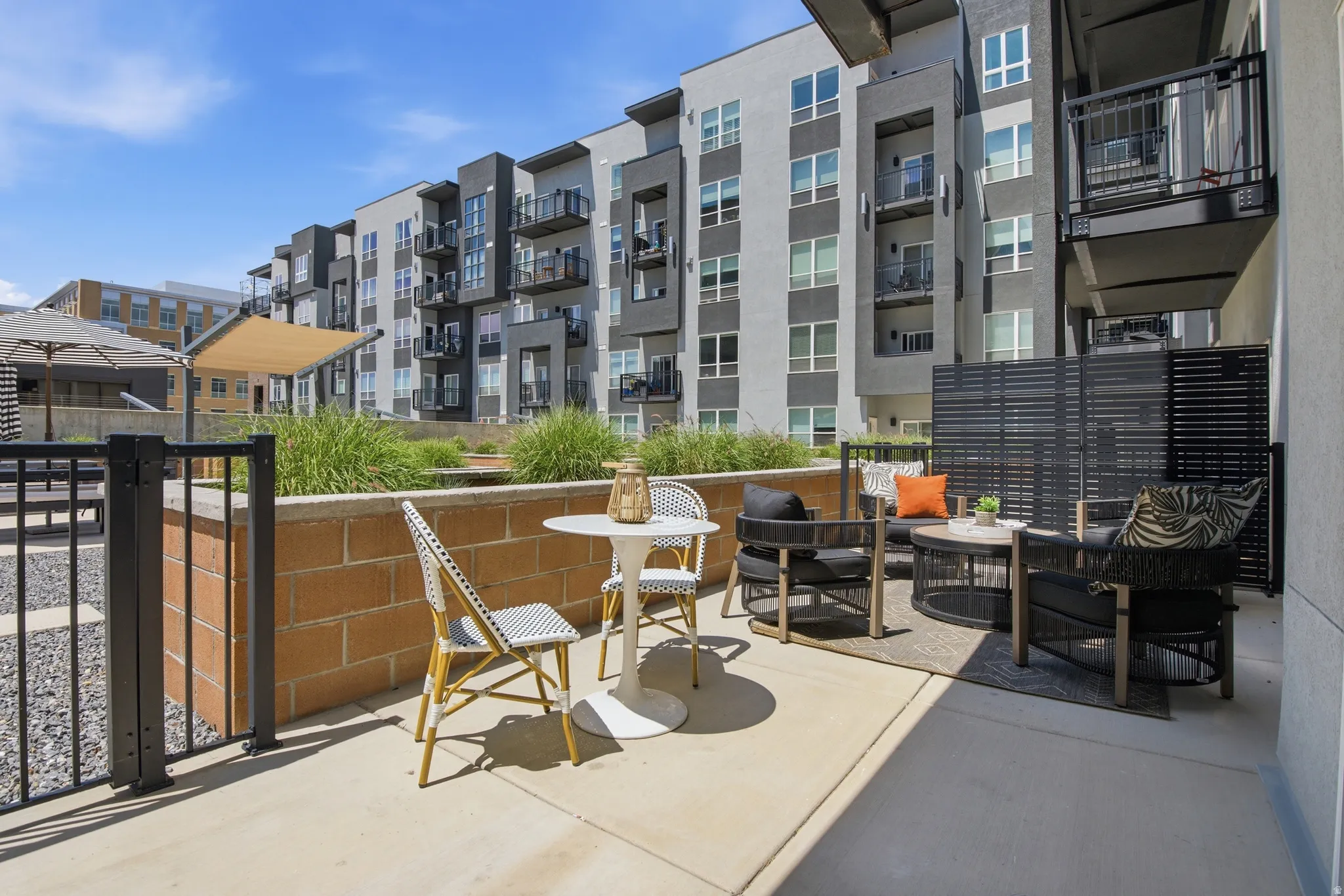 Private patio space featuring concrete paving and a black slatted privacy screen
