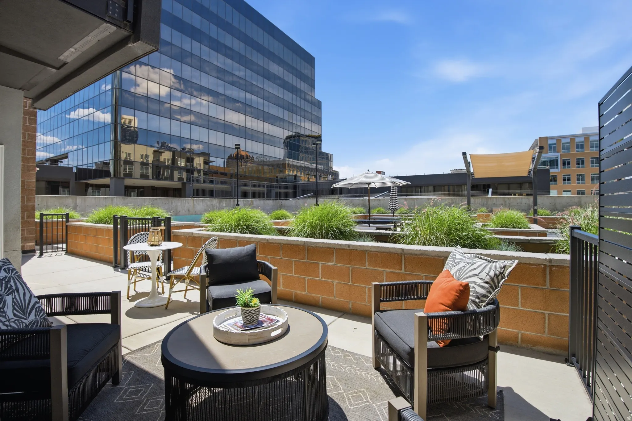 Private outdoor patio featuring light-colored paving and brick planters