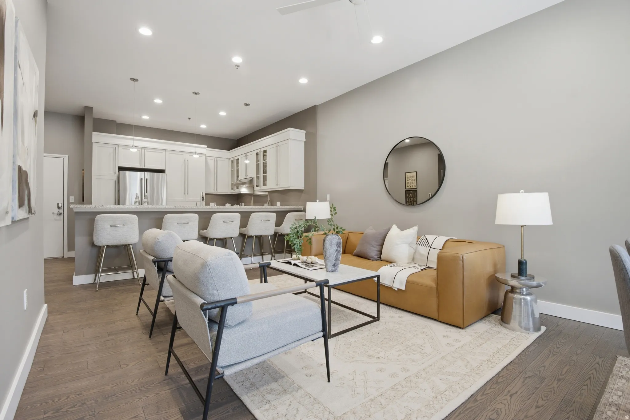 Open-concept living space featuring wood-finish flooring, recessed lighting, and a neutral color palette
