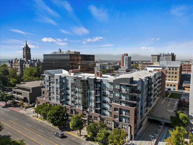 Modern multi-story building featuring balconies and a brick and panel facade