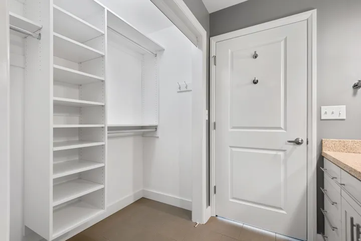 Custom closet system featuring white shelving and hanging rods