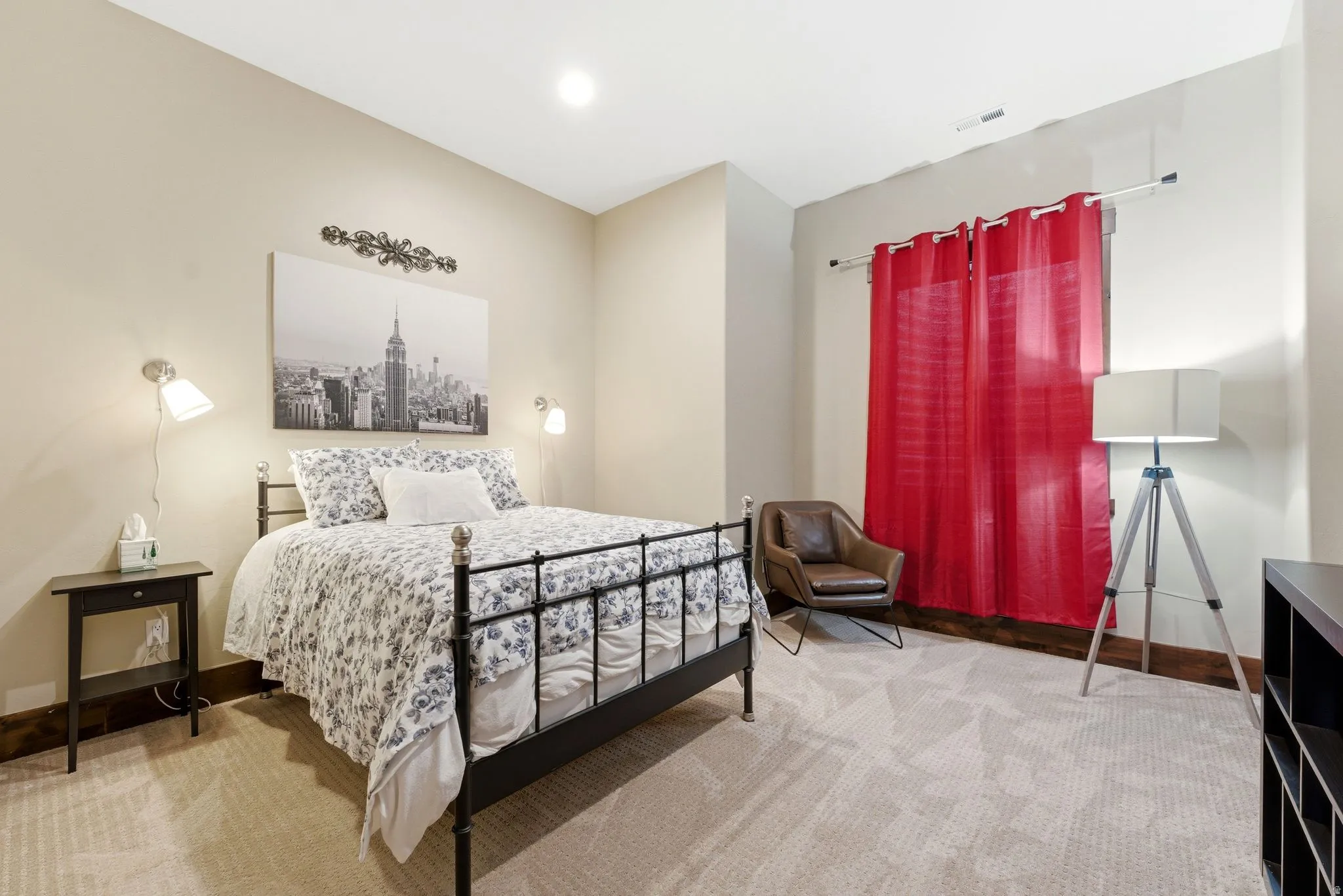 Carpeted room featuring neutral wall tones, a black metal bed frame, and recessed lighting