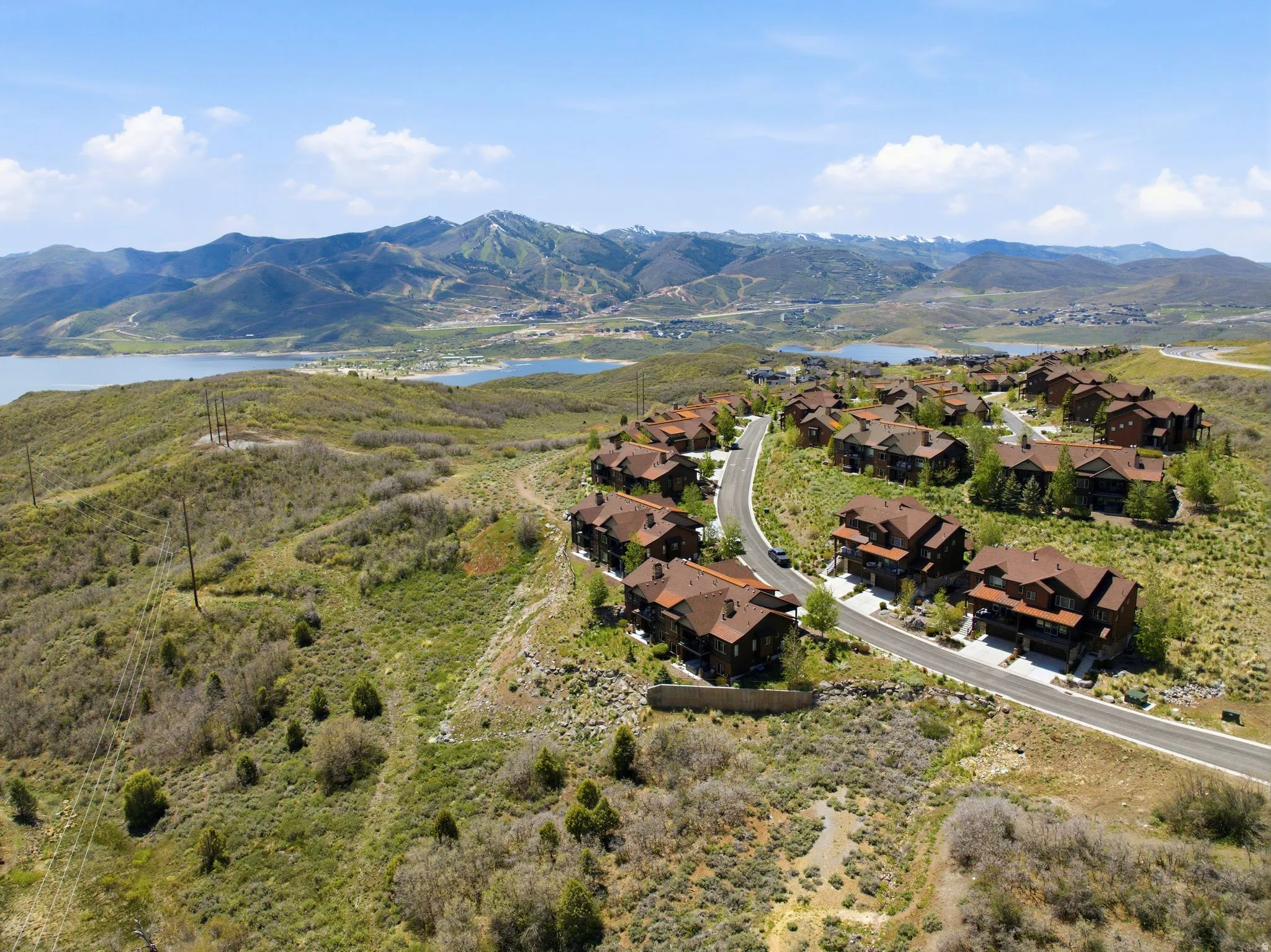 Hillside residential development featuring multi-level homes with brown roofs and dark exteriors