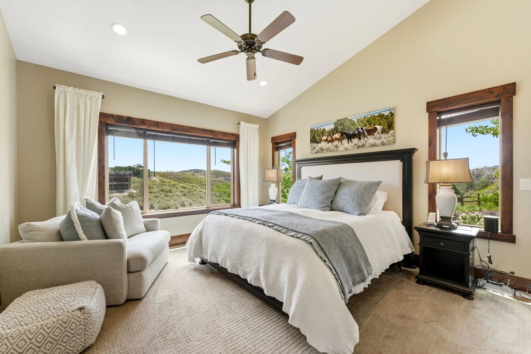Bedroom featuring a vaulted ceiling with a ceiling fan, recessed lighting, and expansive windows with dark wood trim