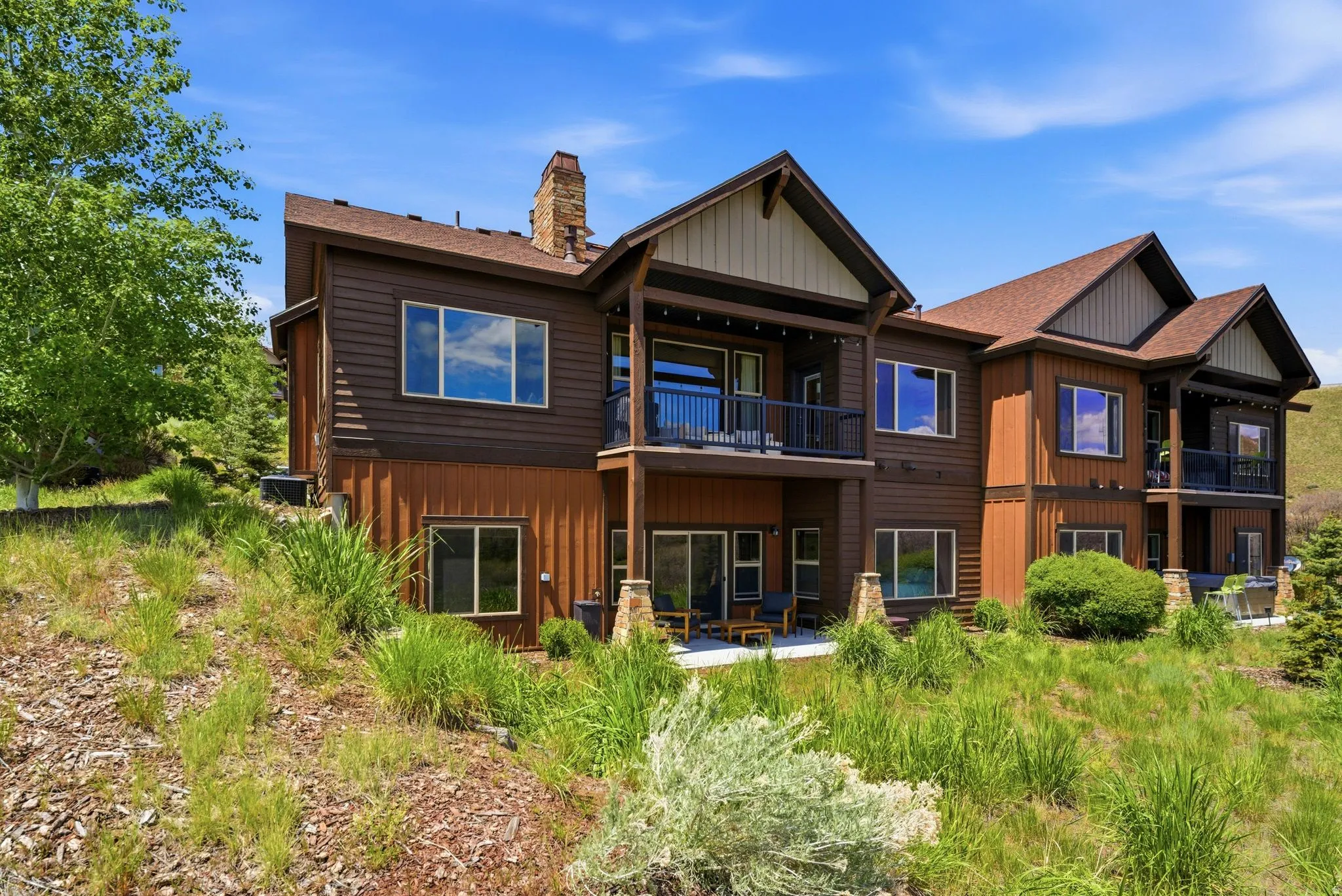 Multi-level dwelling featuring wood siding and a covered balcony