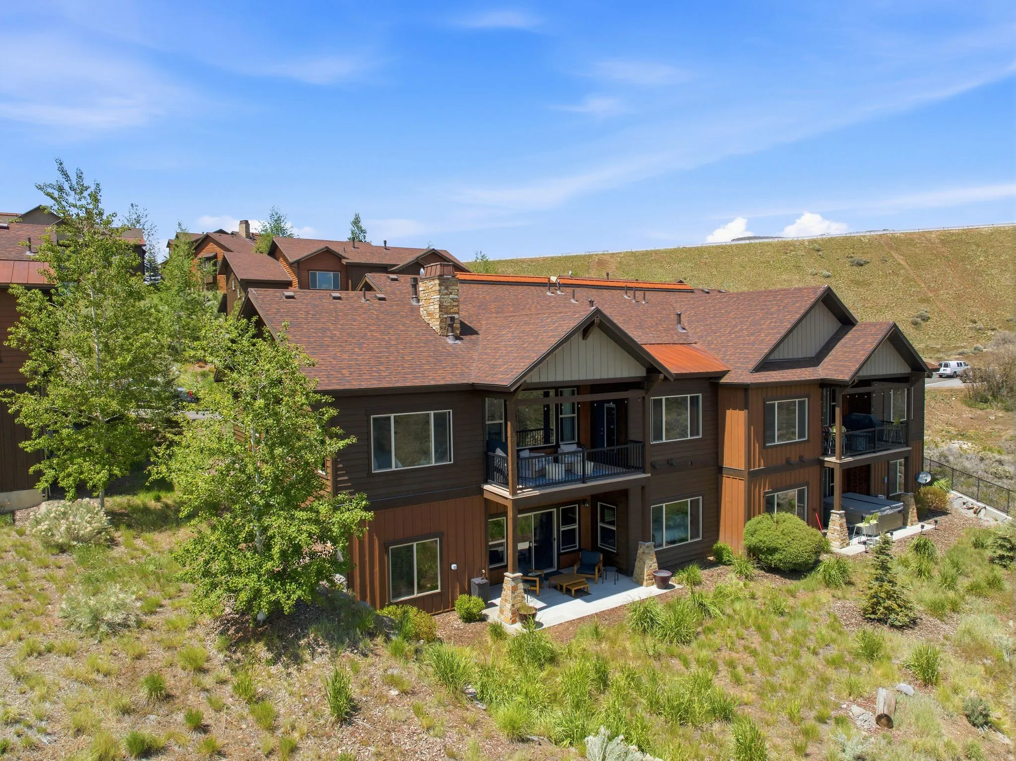 Multi-level residential structure featuring brown siding and a brown shingle roof