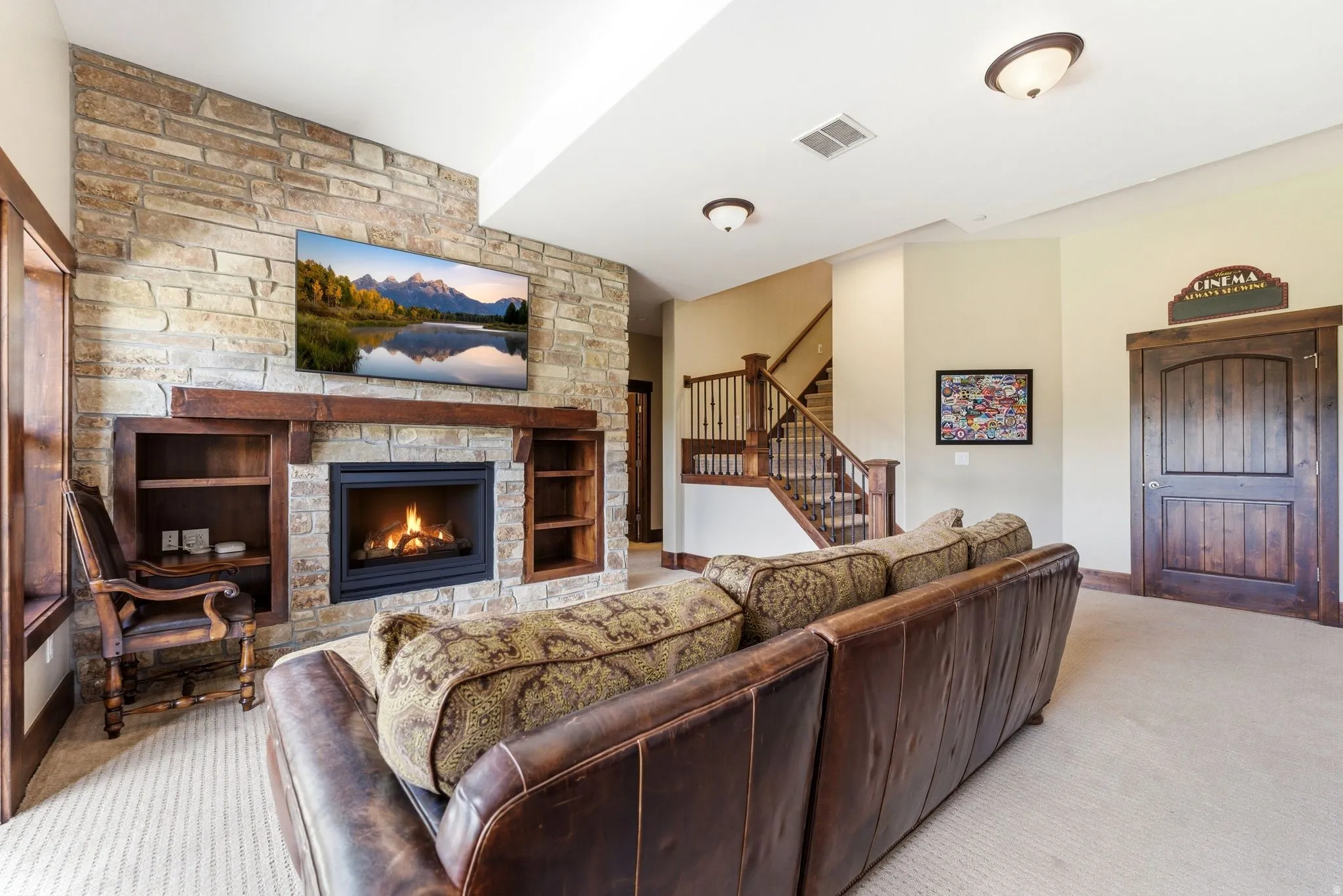 Inviting living space featuring a stone-clad fireplace with an integrated wooden mantel and built-in shelving