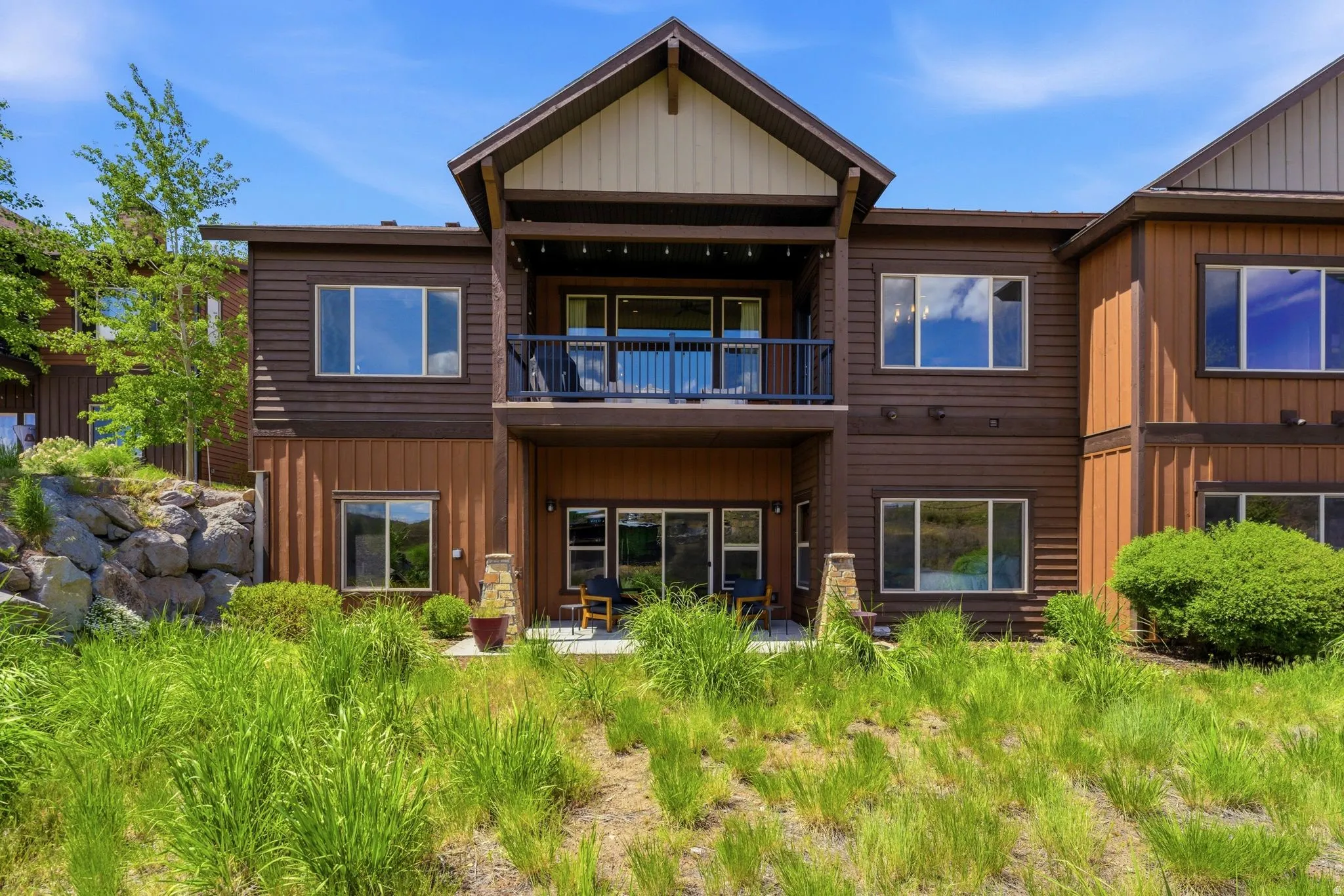 Multi-level exterior with horizontal siding and vertical paneling accents