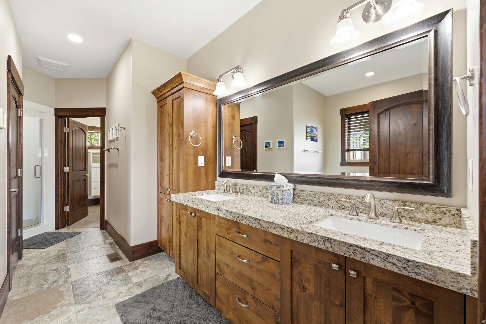 Double vanity featuring granite countertops, undermount sinks, and brushed nickel fixtures
