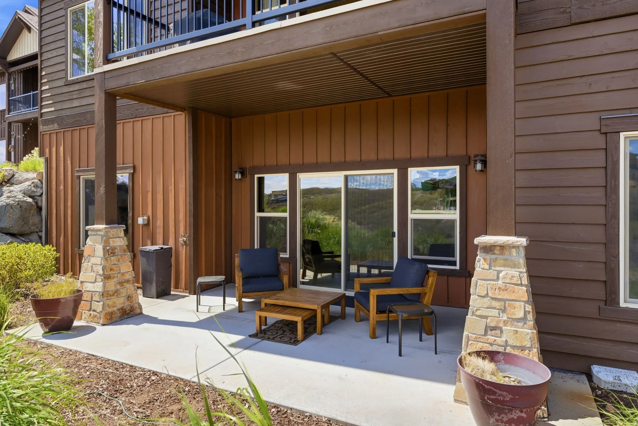 Covered patio featuring a concrete surface and stone-clad support columns