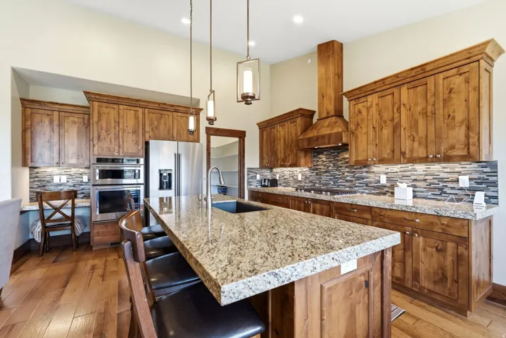 Well-appointed kitchen featuring wood-finish cabinetry and a spacious island with a built-in sink