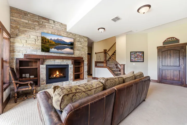 Inviting living space featuring a stone-clad fireplace with an integrated wooden mantel and built-in shelving