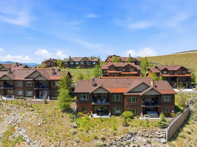 Hillside residential development featuring multi-level structures with brown siding and complementary brown shingle roofs