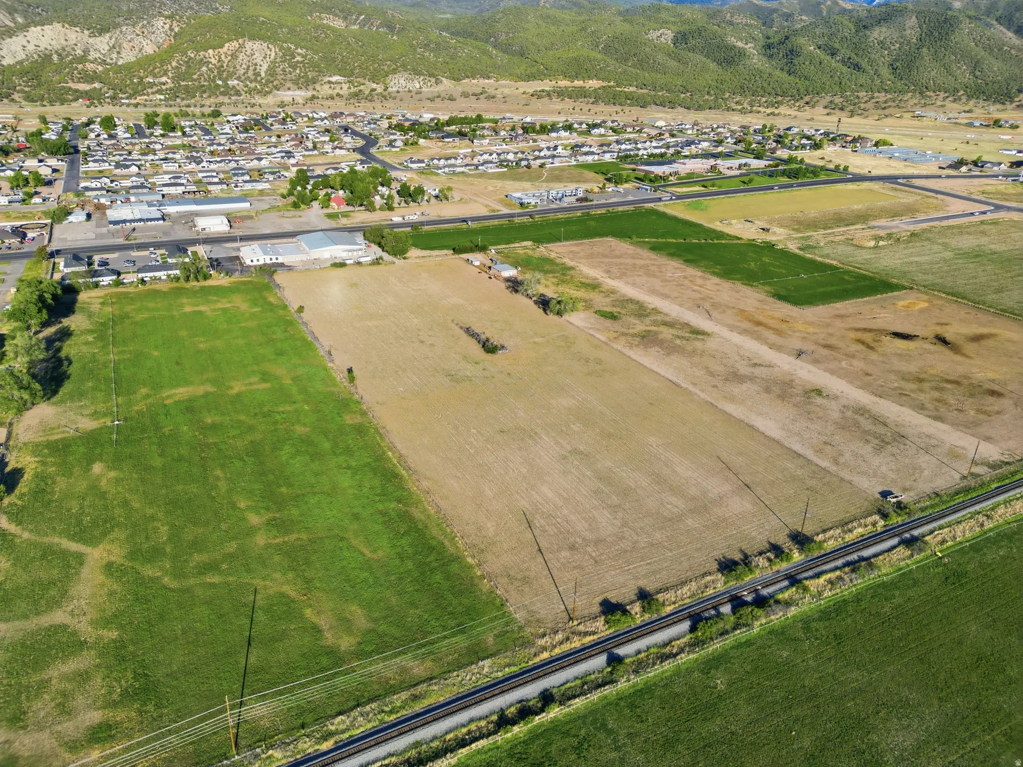 Expansive land parcel featuring diverse terrain, including cultivated fields and lush green areas