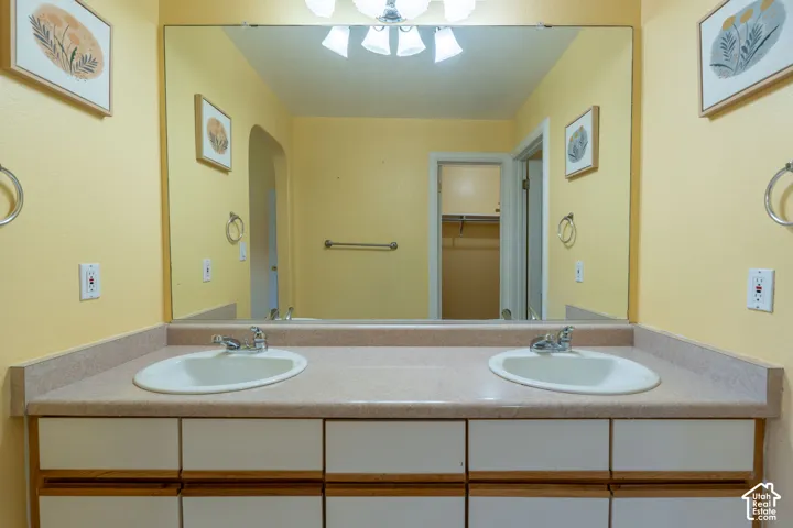 Dual vanity with integrated sinks and chrome faucets, set below a full-width mirror