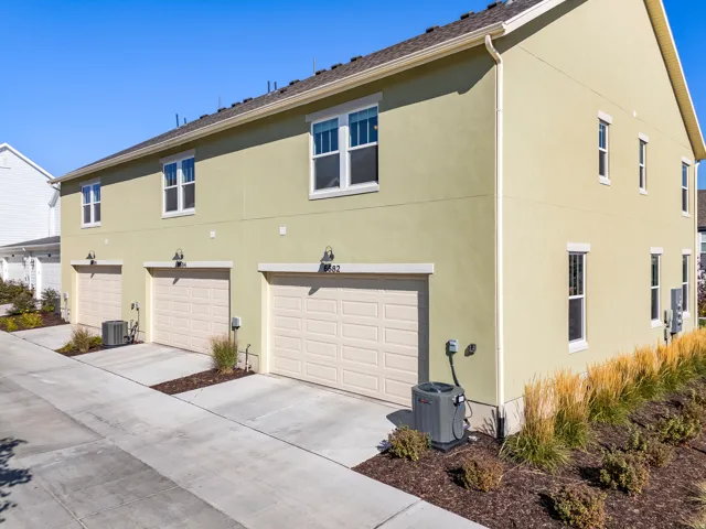 Stucco exterior with multiple garage bays and white-framed windows