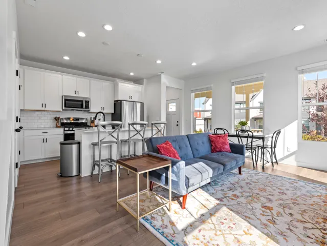 Open-concept living area featuring wood-finish flooring, recessed lighting, and white walls