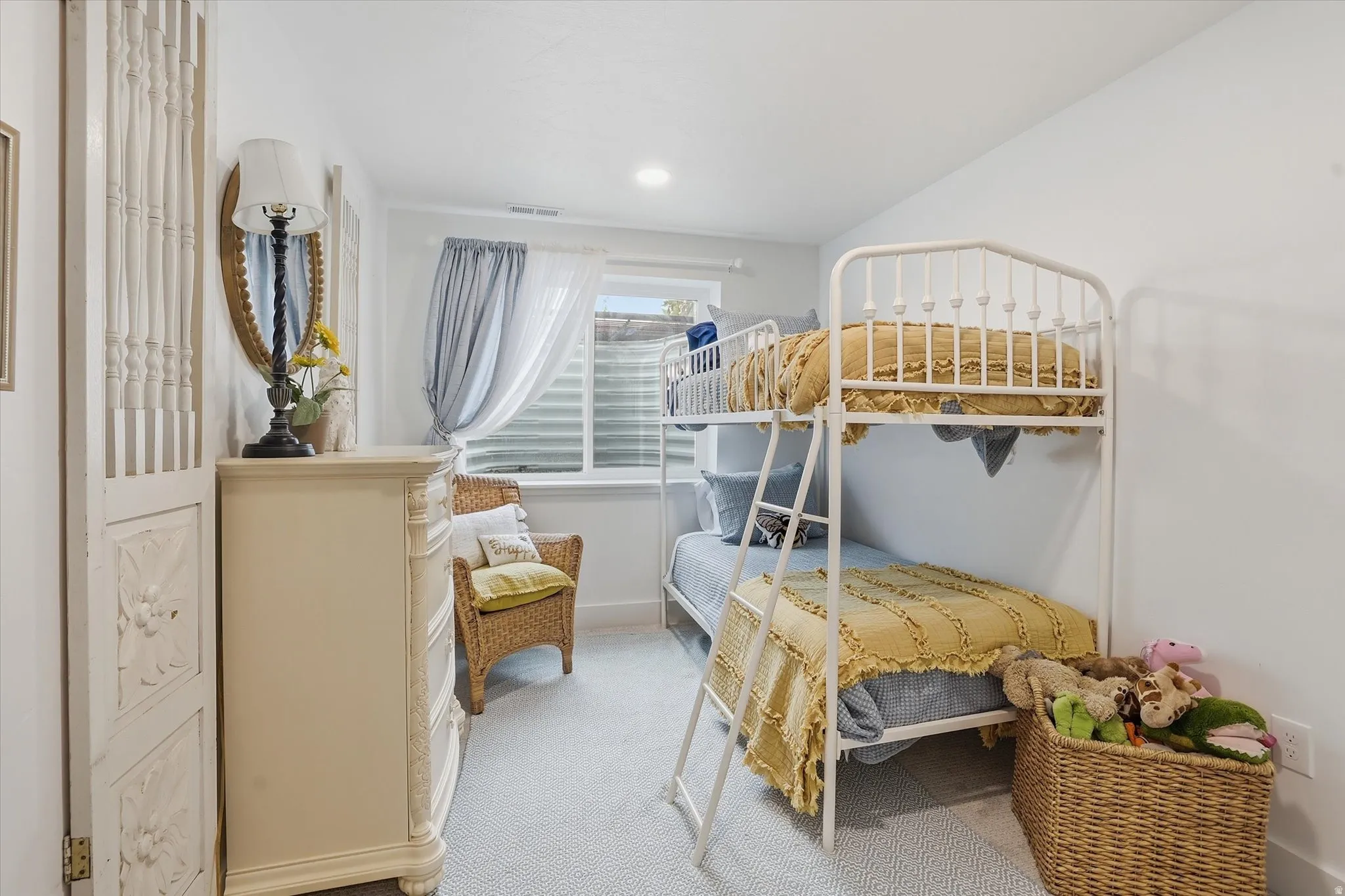 Bright interior space featuring a window with privacy blinds, recessed lighting, and light-toned carpet flooring