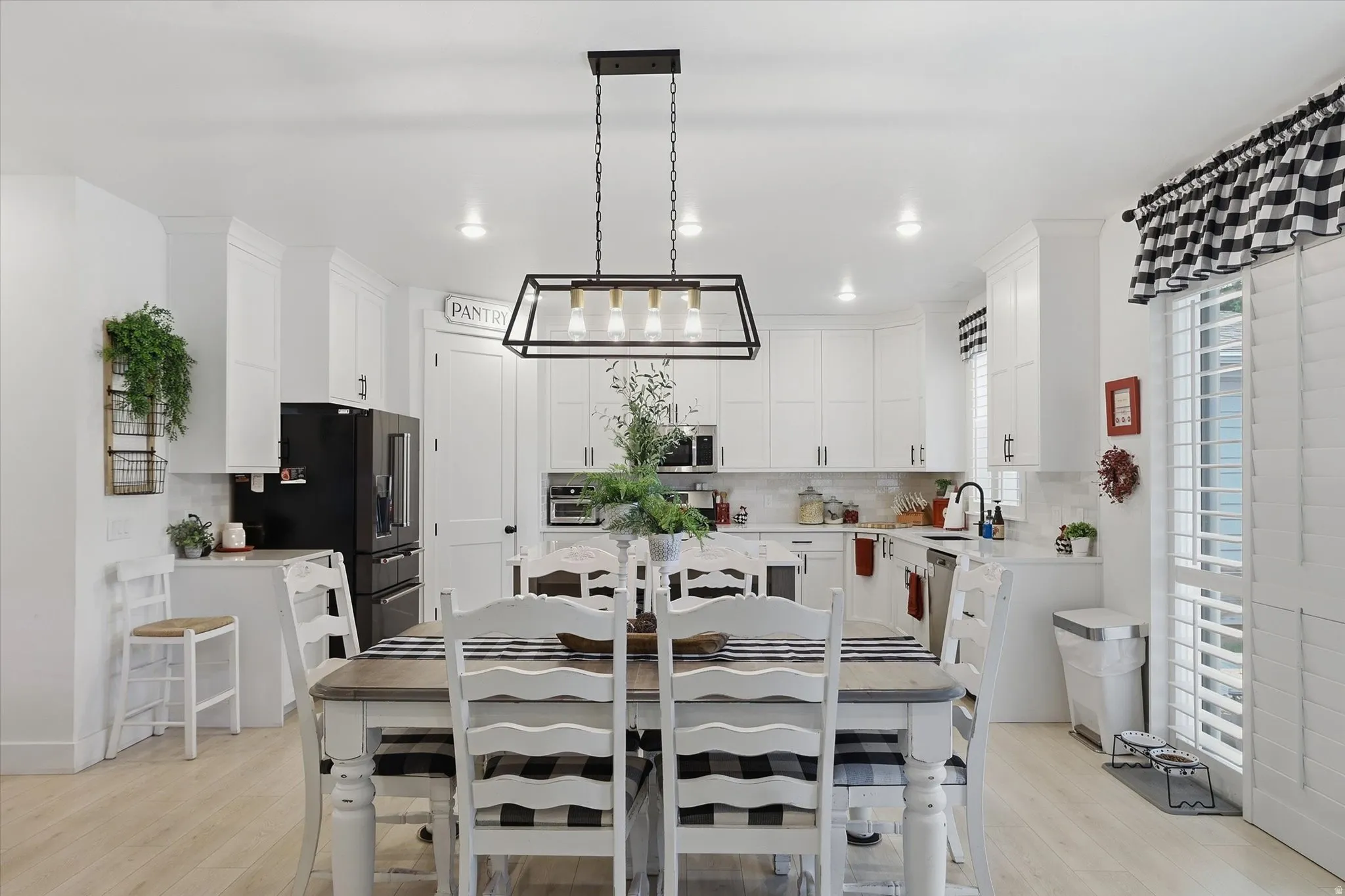 Open-concept dining area featuring a linear chandelier with exposed bulbs