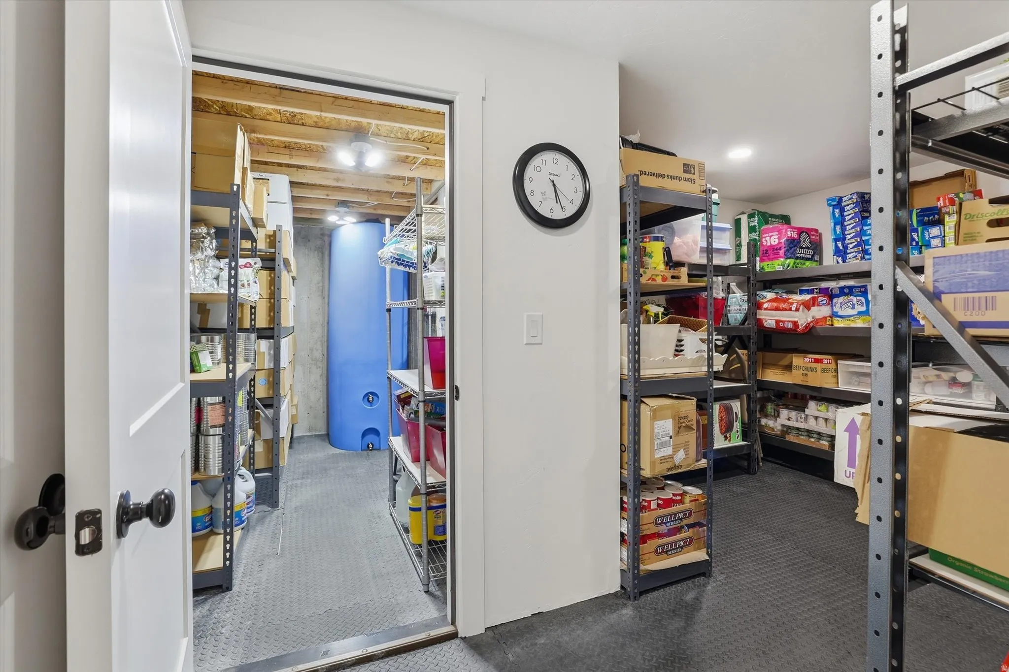 Organized storage area featuring industrial shelving, durable rubber flooring, and an exposed wood beam ceiling