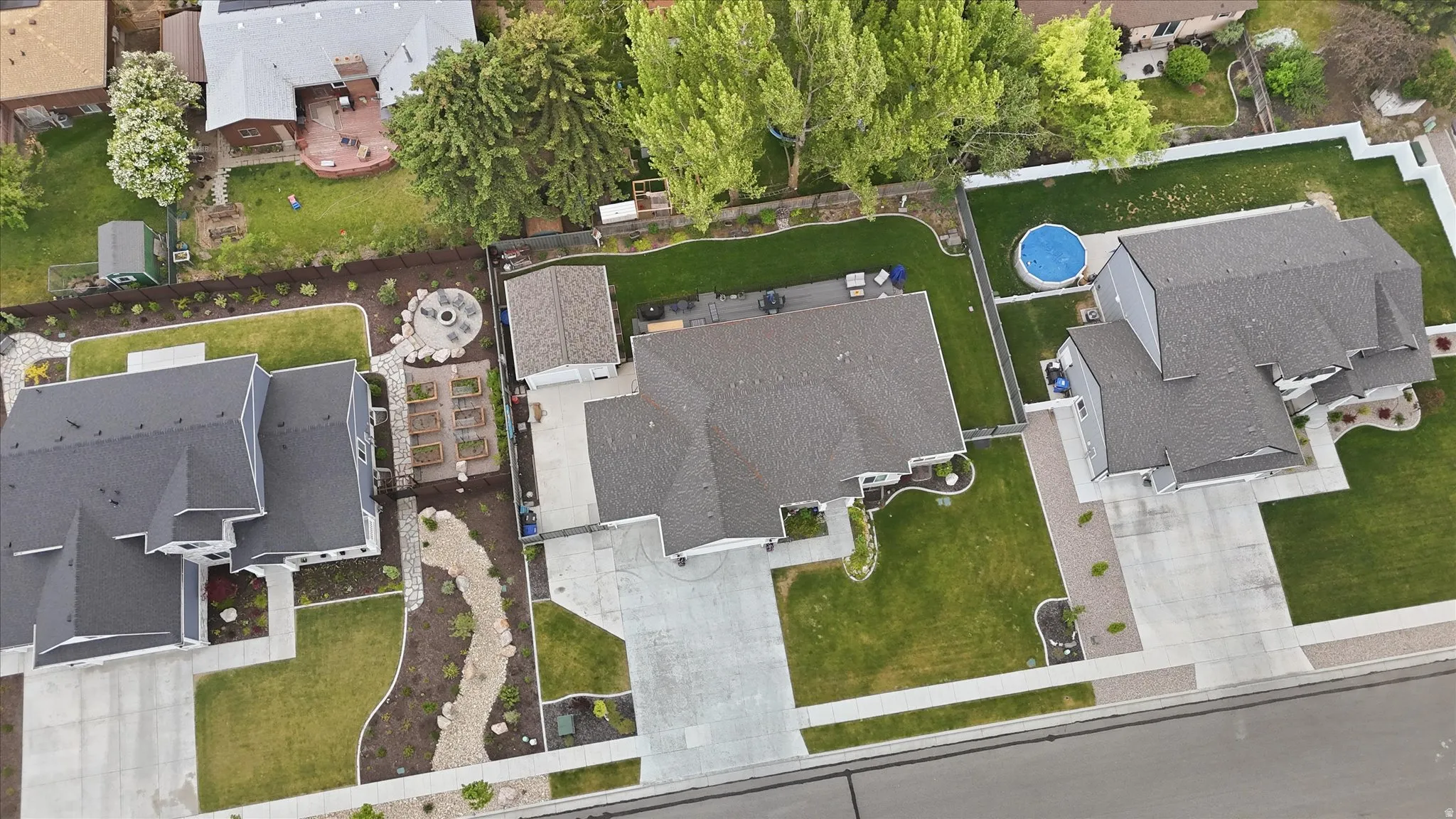 Expansive lot featuring a large residential structure with a gray roof and light-colored siding