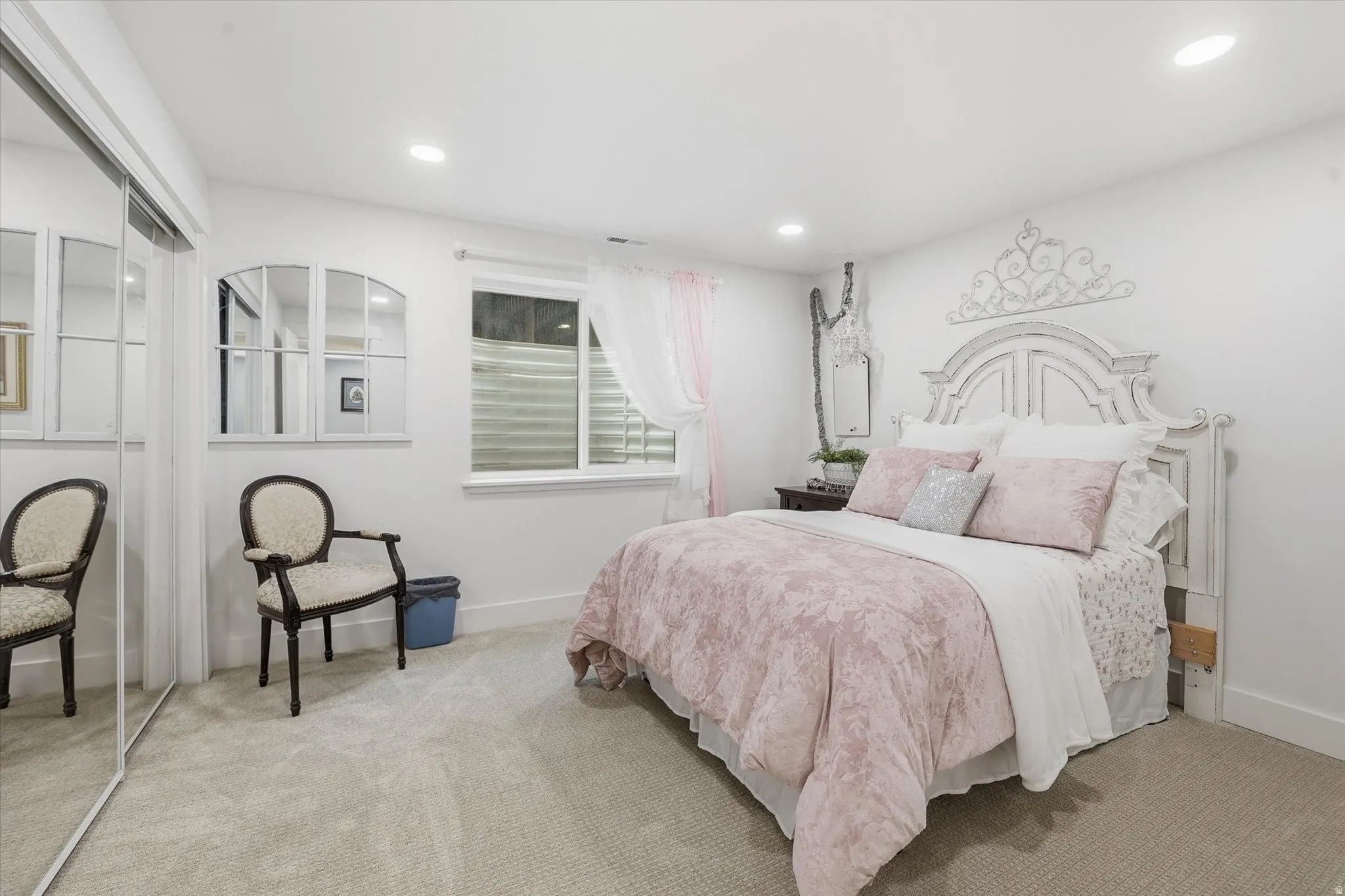 Carpeted bedroom featuring recessed lighting, a window with horizontal blinds, and a mirrored closet door