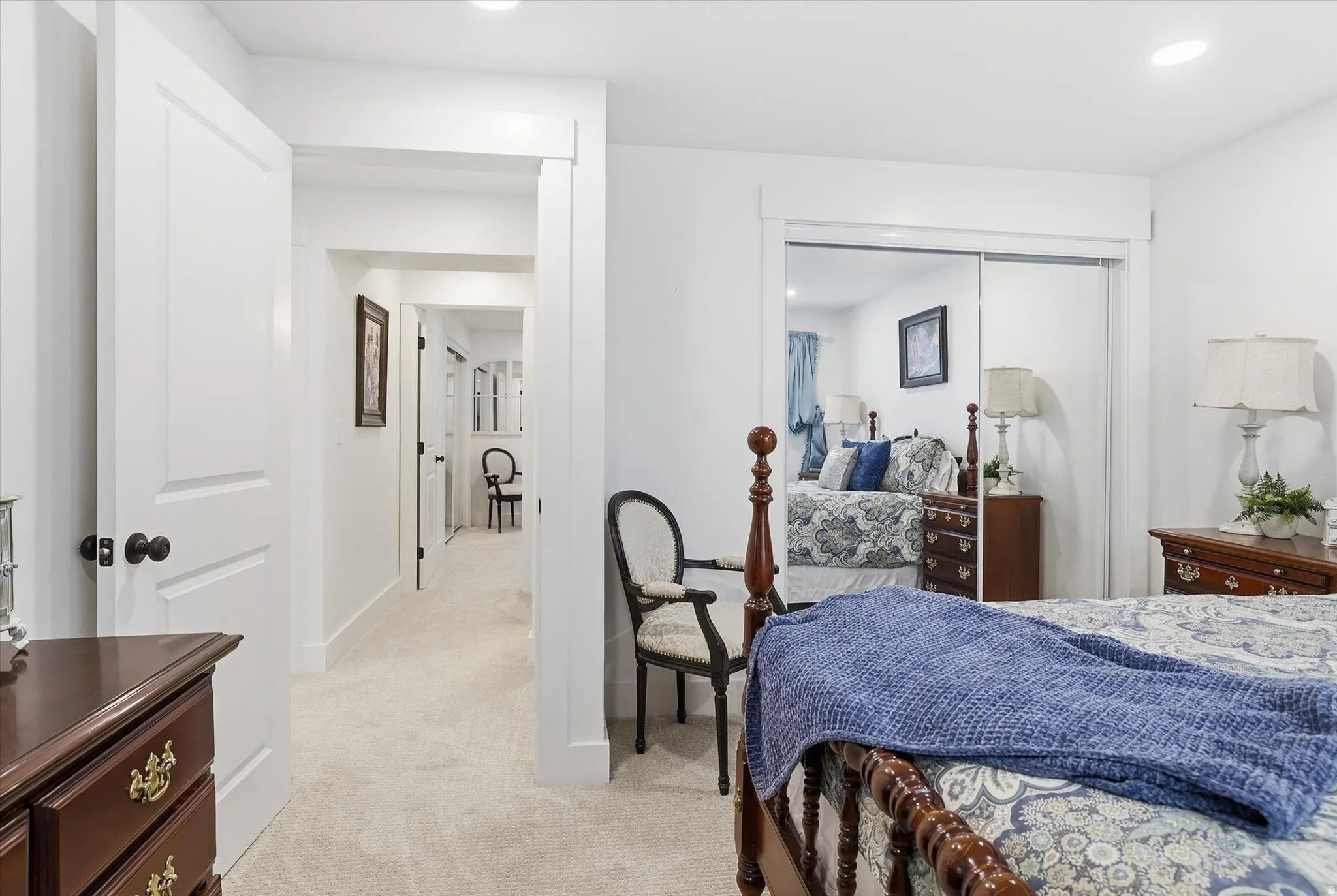 Bedroom featuring neutral-toned carpeting, white walls, and a mirrored closet with sliding doors