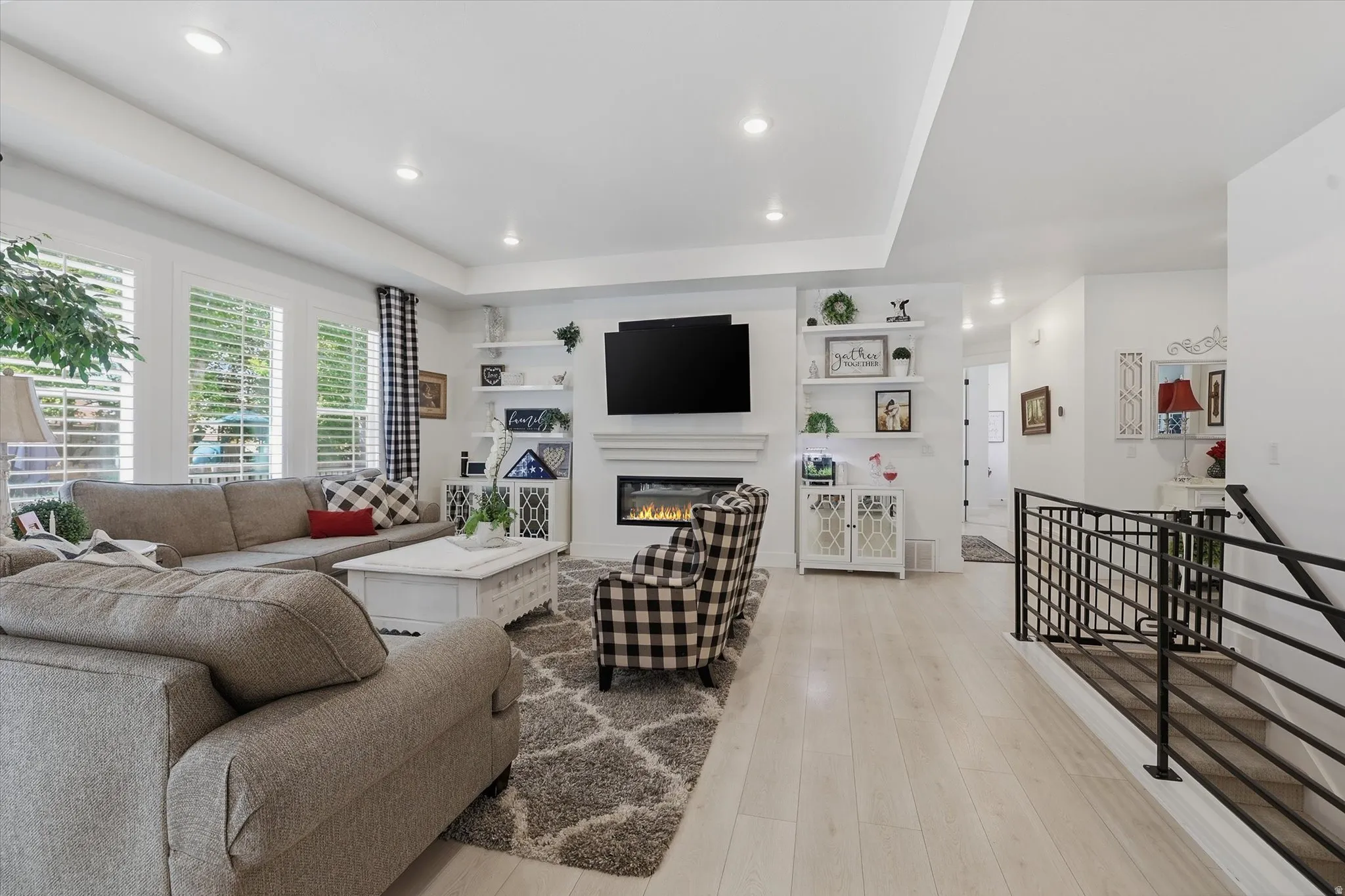 Bright living area featuring wood-finish flooring and a central fireplace