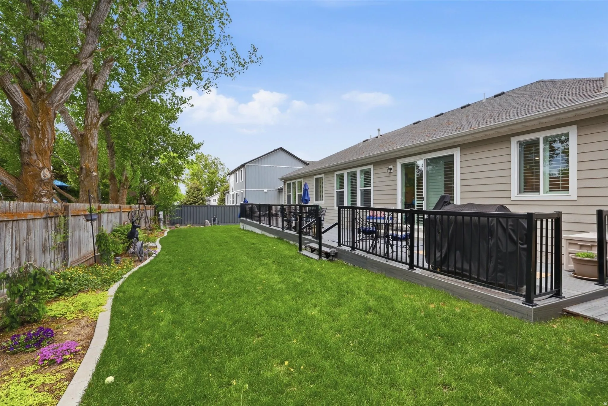 Expansive backyard featuring a lush lawn and garden beds