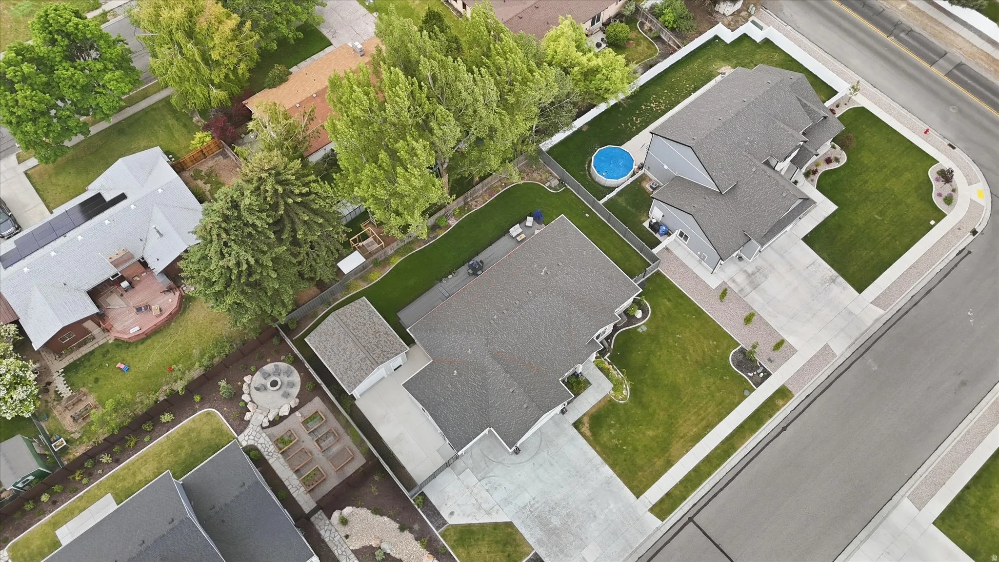 Aerial view showcasing a corner lot property with a detached garage