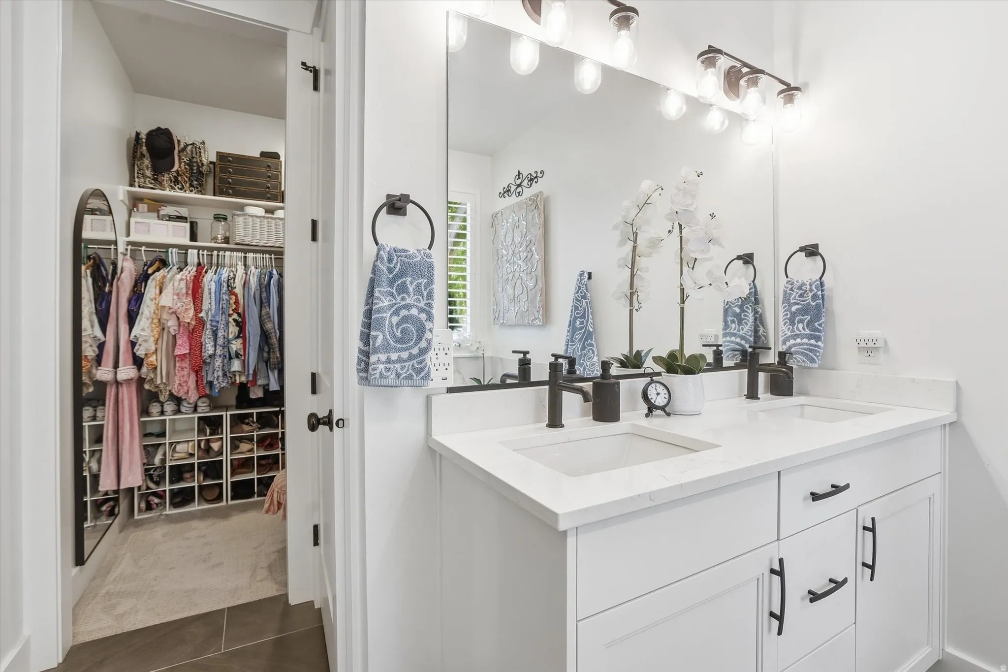 Dual vanity with white cabinetry, quartz countertops, and matte black fixtures