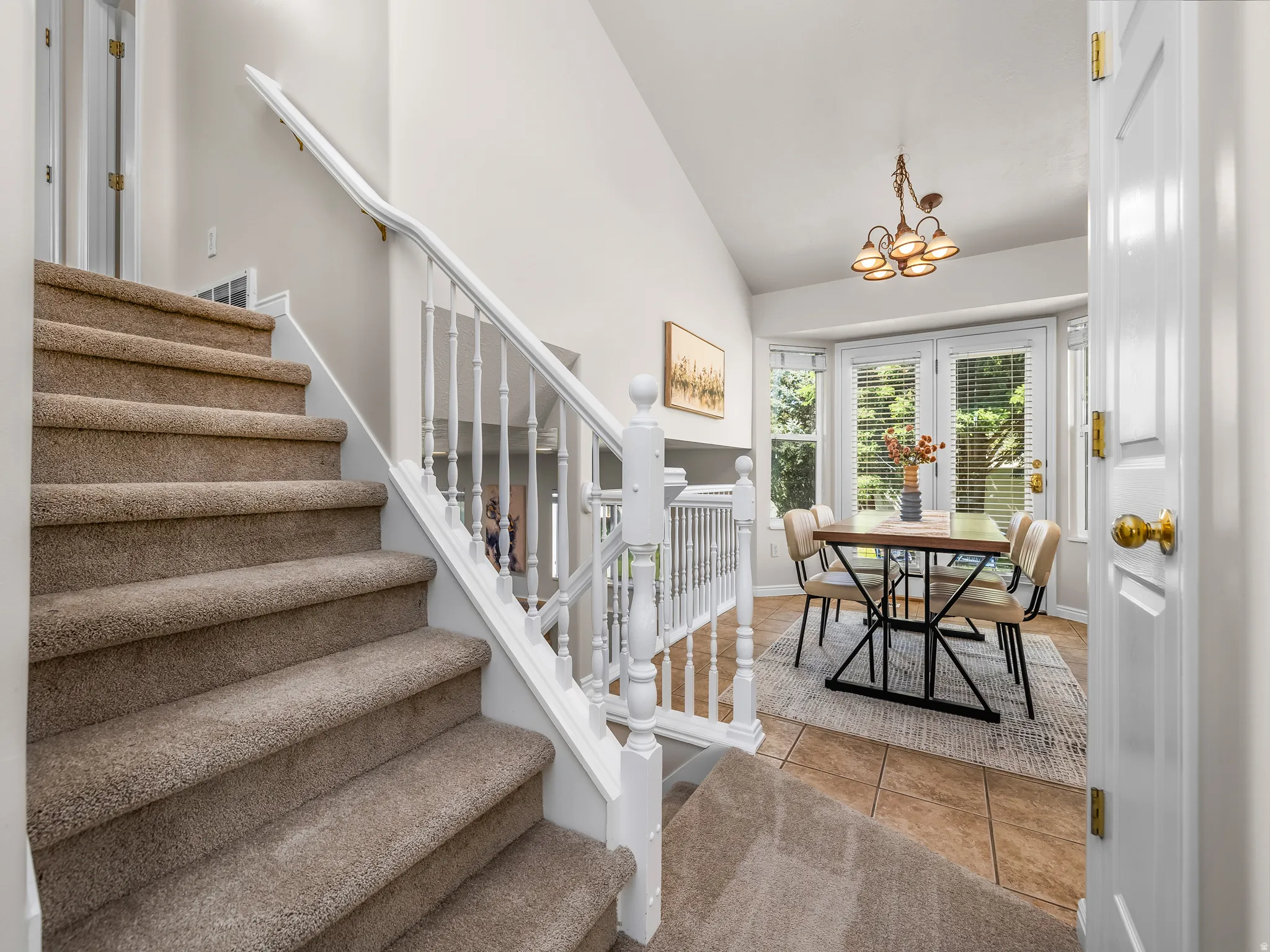 Carpeted staircase with white balusters and handrail