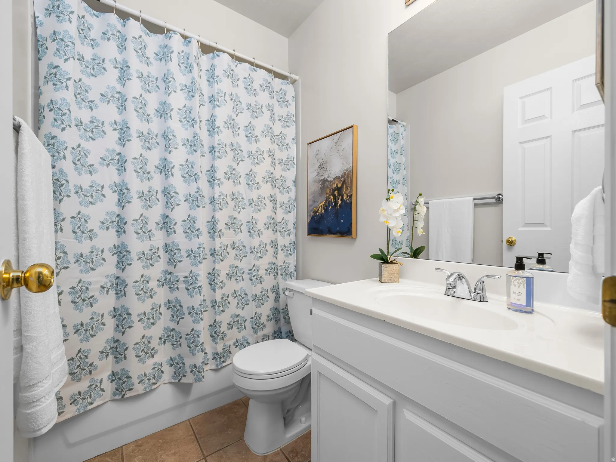 Bathroom featuring a vanity with an integrated sink, polished chrome faucet, full-width mirror, and a white paneled door