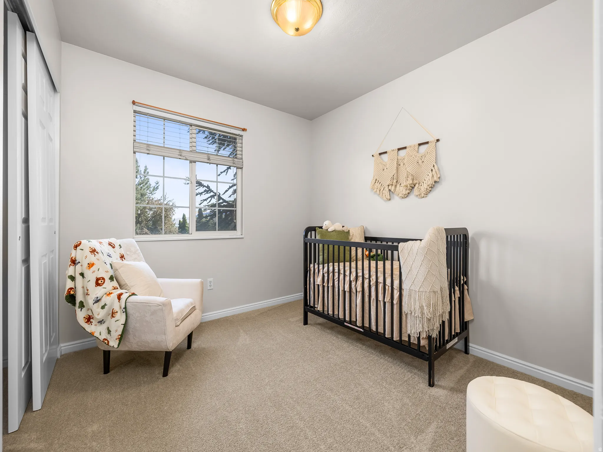Carpeted room with a double-pane window, horizontal blinds, and a flush mount ceiling light fixture