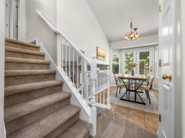Carpeted staircase with white balusters and handrail
