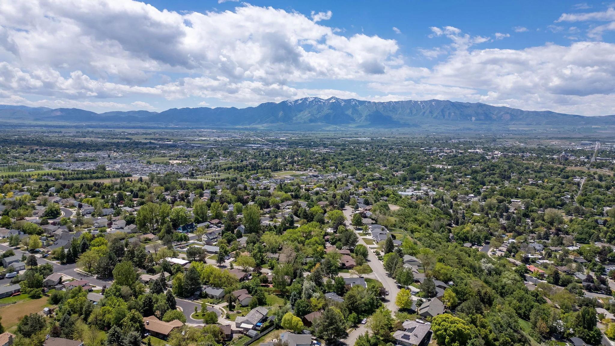 Expansive aerial perspective showcasing a residential landscape set against a backdrop of distant mountains