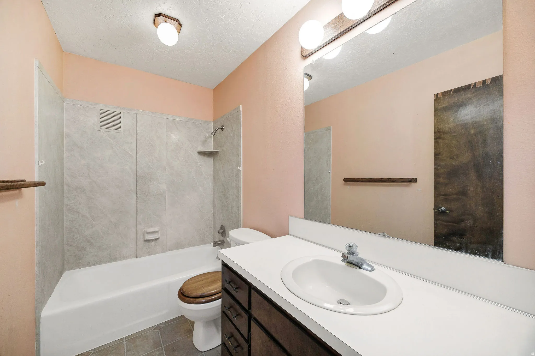 Full bathroom featuring a single vanity with dark wood-finish cabinetry, a white countertop, and an oval undermount sink