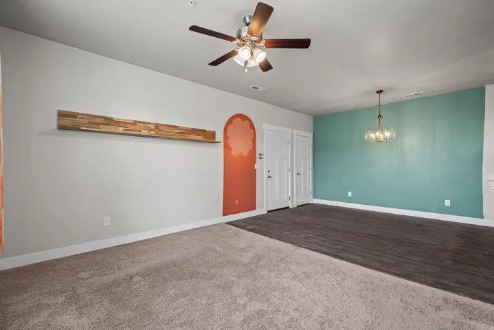 Spacious room featuring a partial wall with wood-finish flooring and a partial wall with carpet