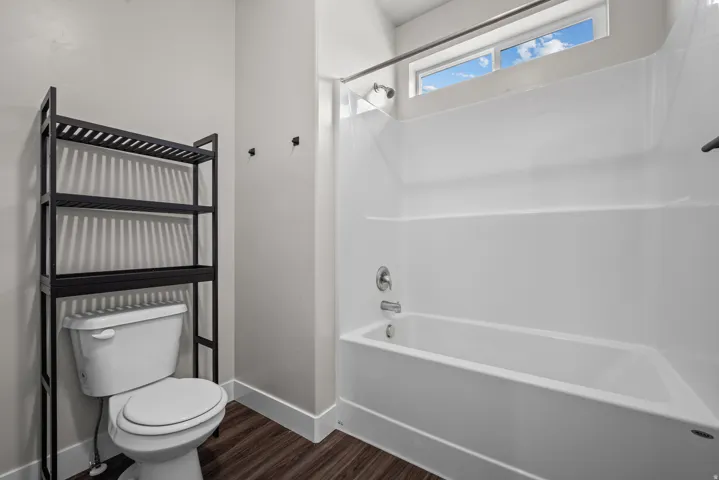 Full bathroom featuring a white tub/shower combination, polished chrome fixtures, and a high transom window