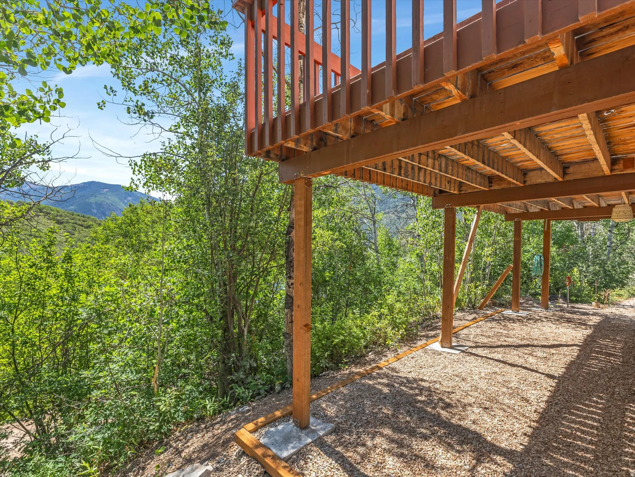 Elevated wood deck with a slatted railing, supported by timber posts