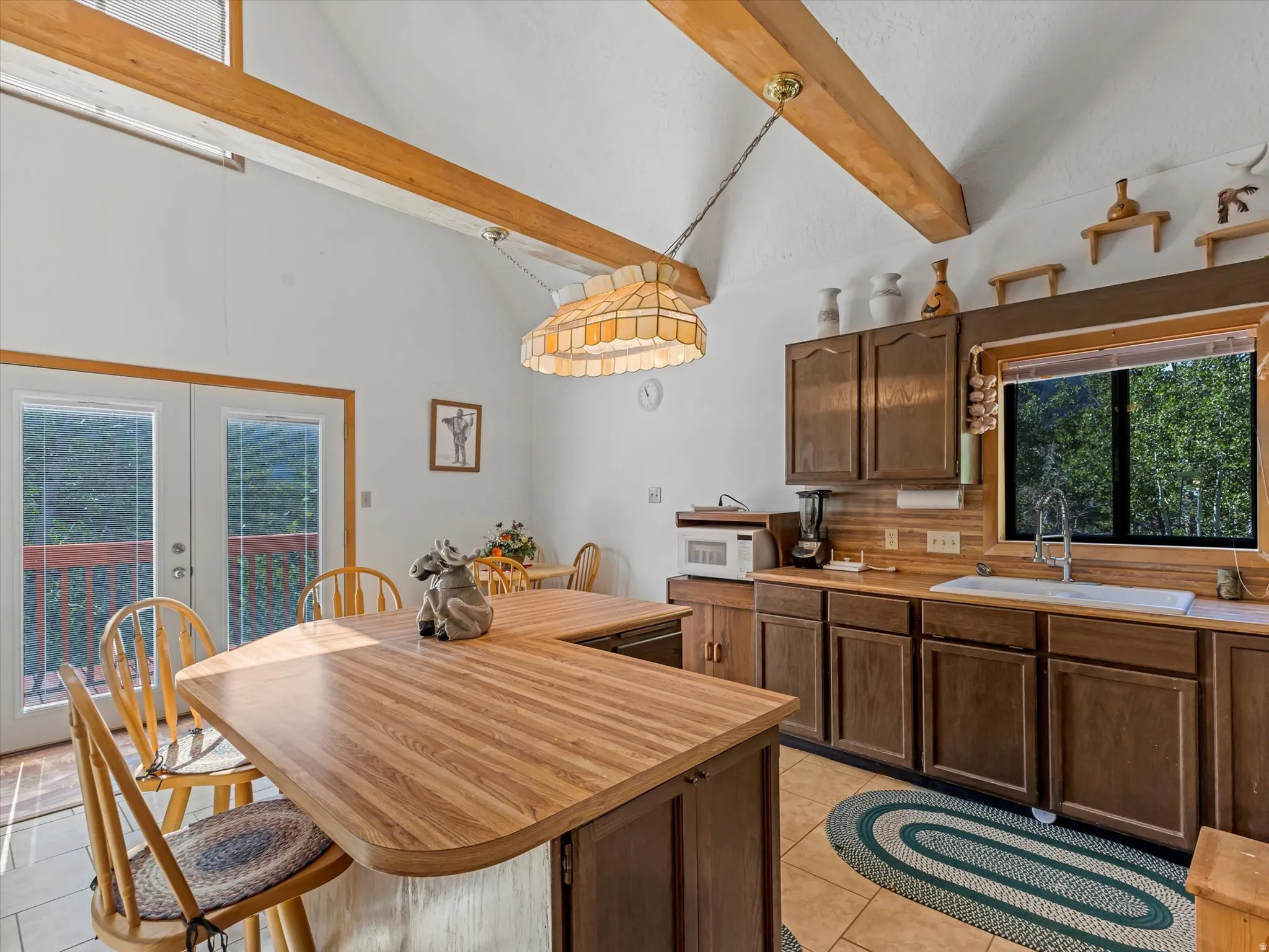 Kitchen featuring wood-finish countertops, wood cabinetry, and a double basin sink with an arched faucet