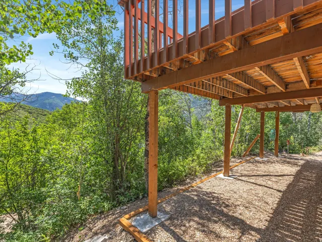 Elevated wood deck with a slatted railing, supported by timber posts
