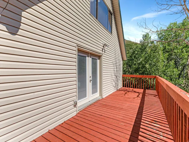 Spacious outdoor deck with a red-stained wood surface and matching wood railings
